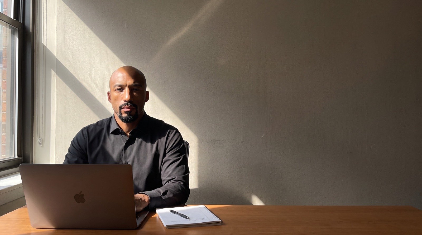 Marcell Jackson at a desk with a laptop and a notepad, Chicago.